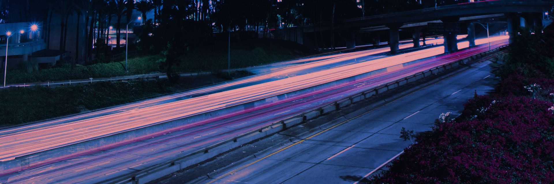 Light trails from traffic on a city freeway at night.